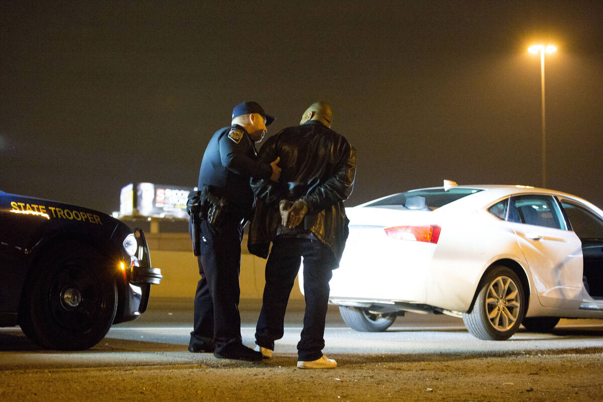 Nevada Highway Patrol trooper Ervin Raab, left, arrests a DUI suspect near the Spaghetti Bowl o ...