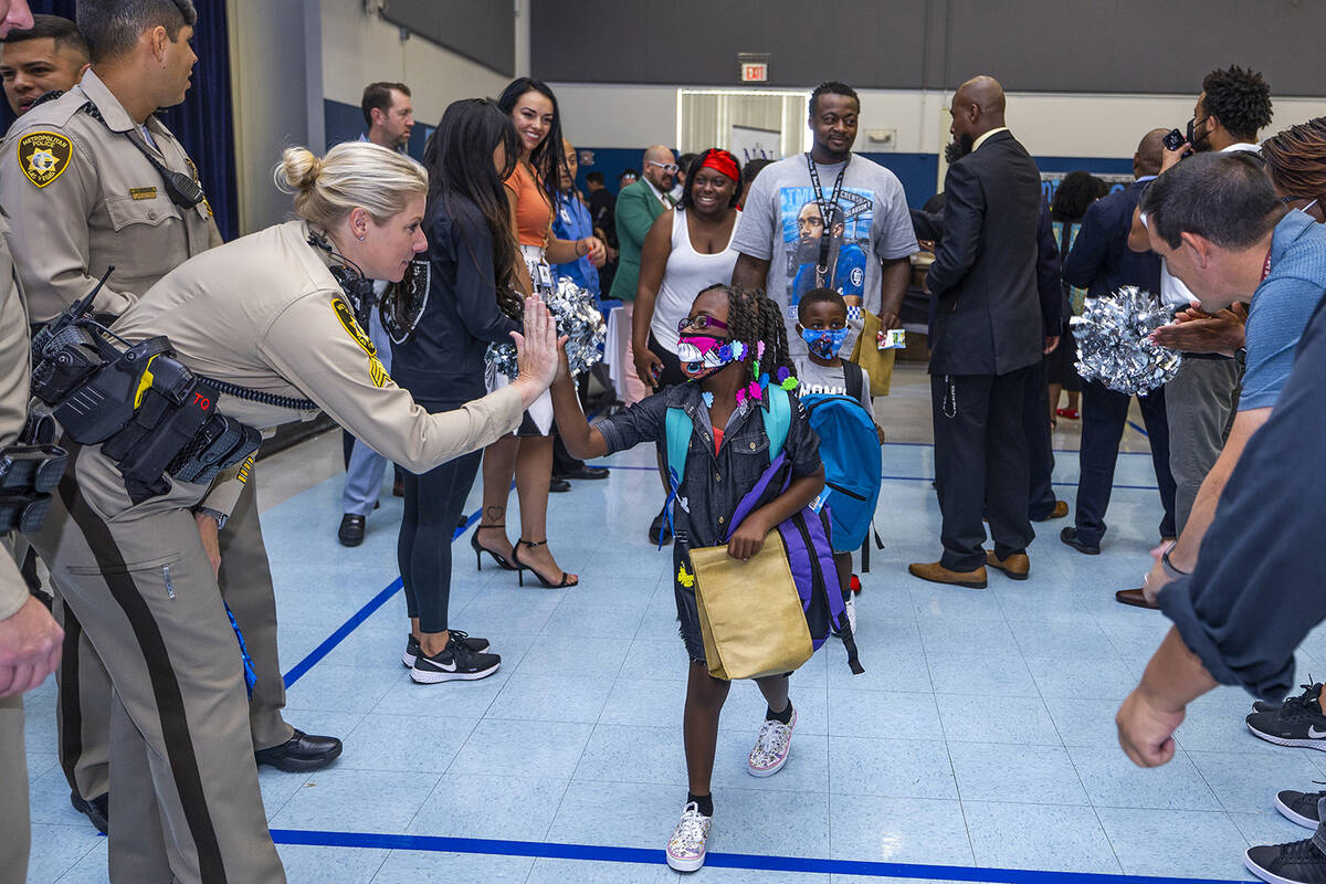 Metro officers join others in a red carpet welcome for students on their first day of school at ...