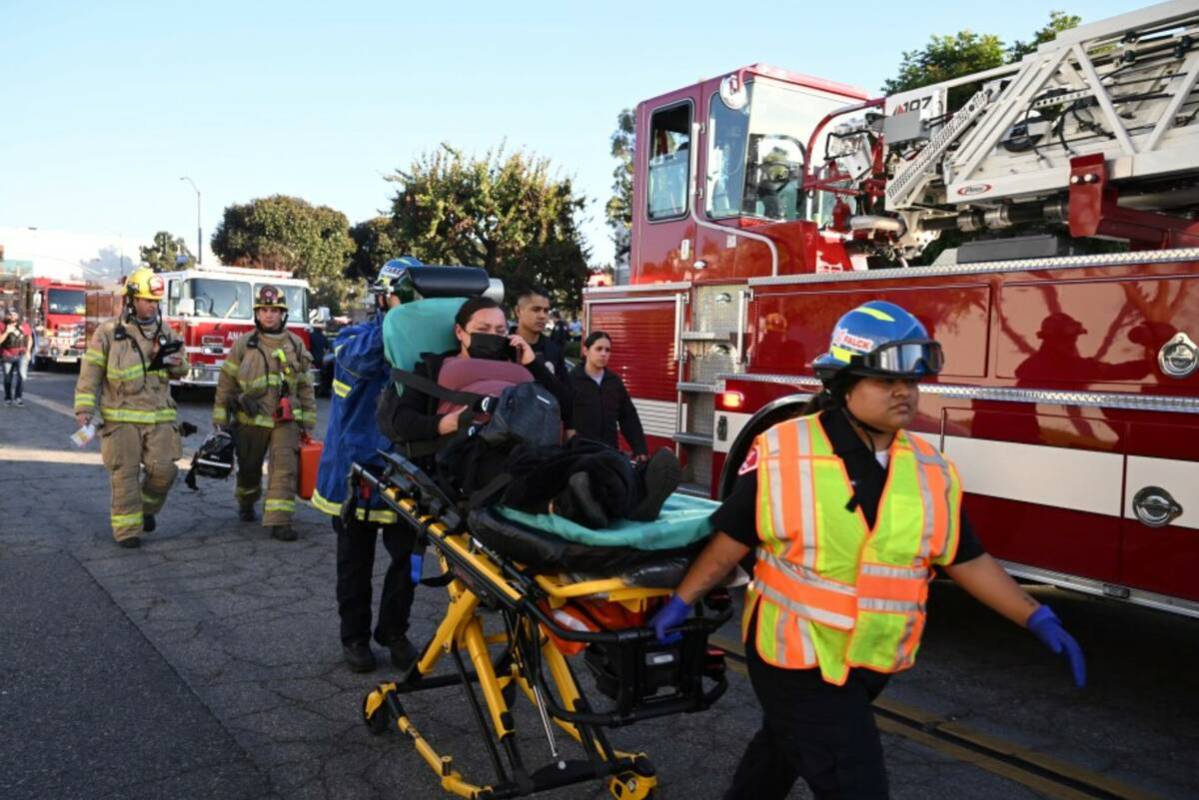 A woman is carried on a stretcher near the site of a plane crash, Thursday, Jan. 2, 2025, in Fu ...