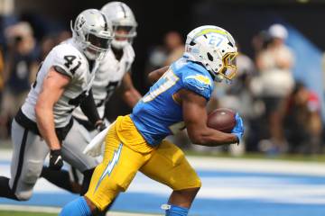 Los Angeles Chargers running back J.K. Dobbins (27) scores past Raiders linebacker Robert Spill ...