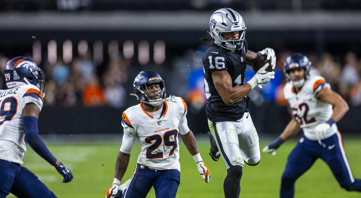 Raiders wide receiver Jakobi Meyers (16) elevates for a catch as Denver Broncos cornerback Ja'Q ...