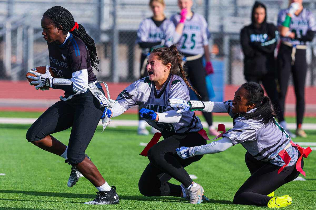 Shadow Ridge running back Savanna McDow (21) runs the ball as one of her flags is yanked during ...