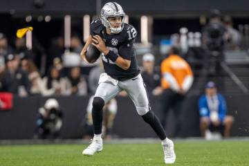 Raiders quarterback Aidan O'Connell (12) scrambles on a play during the first half of an NFL ga ...