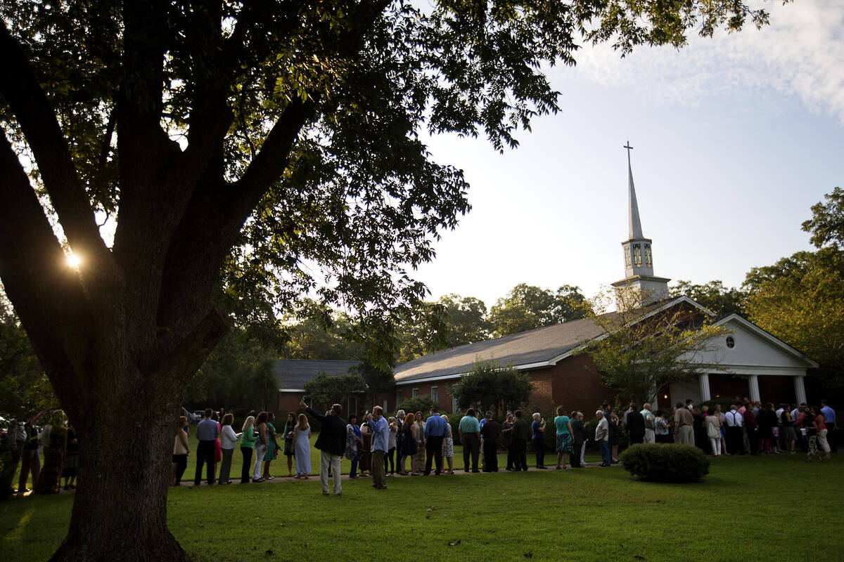 FILE - People wait in line outside Maranatha Baptist Church in Plains, Ga., to get into a Sunda ...