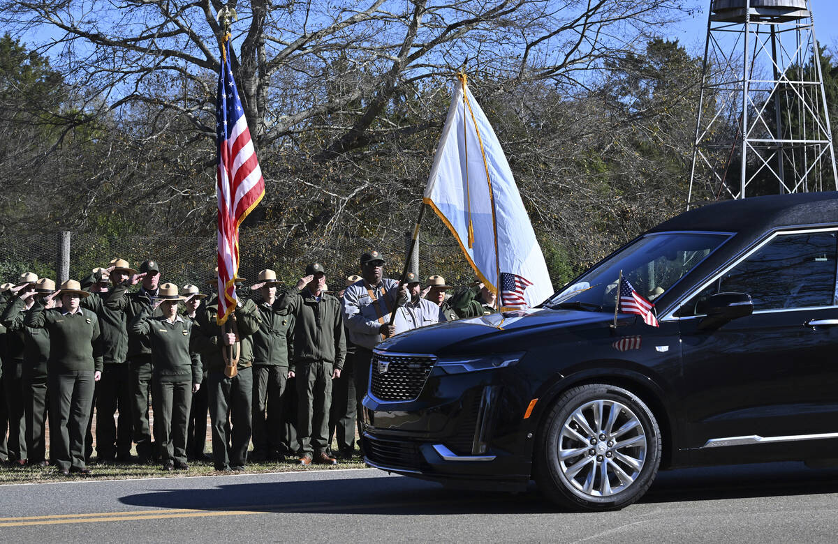 NPS employees, based out of Sumter County, Ga., salute the hearse carrying the flag-draped cask ...