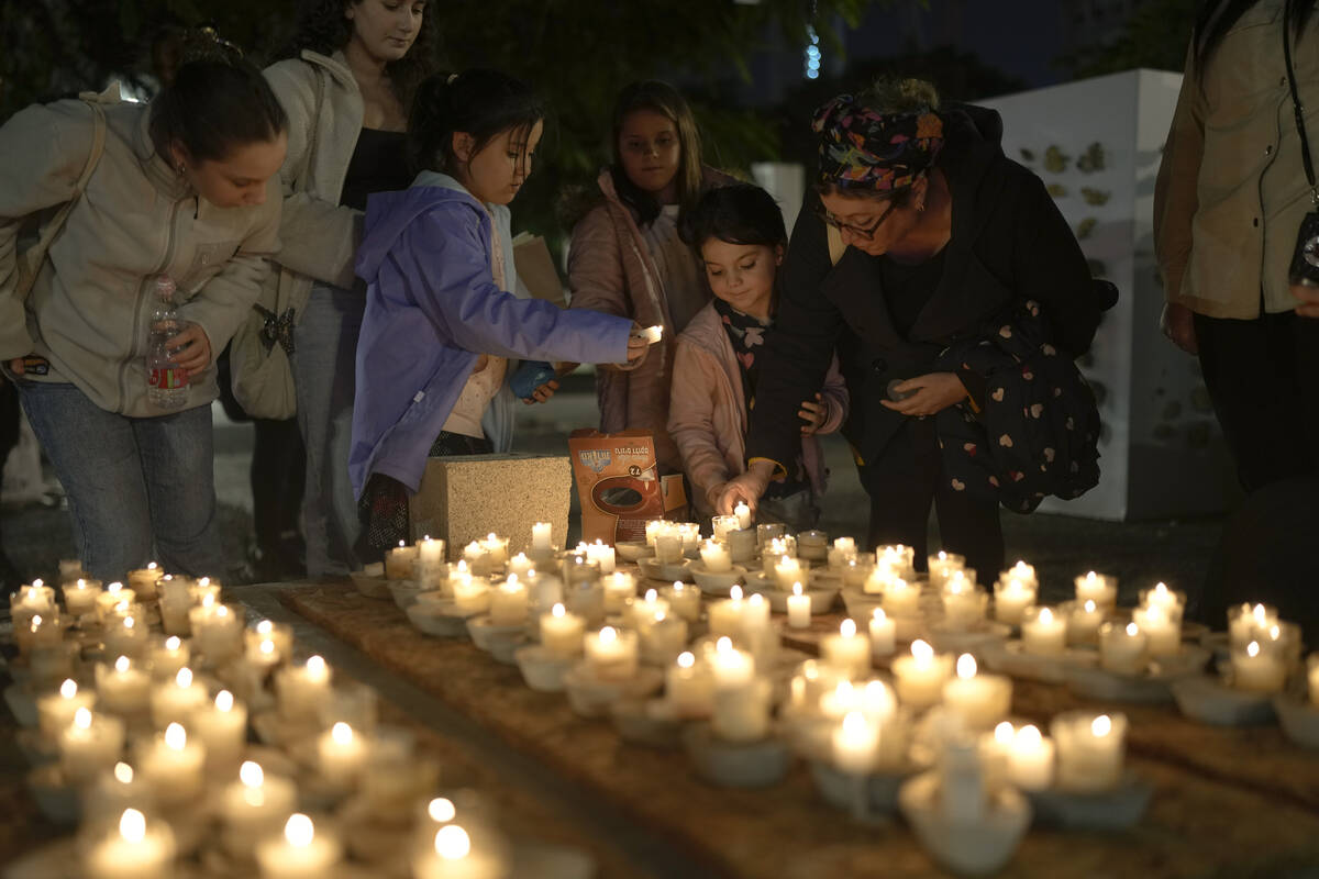 People light candles during a meeting demanding the immediate release of hostages held by Hamas ...