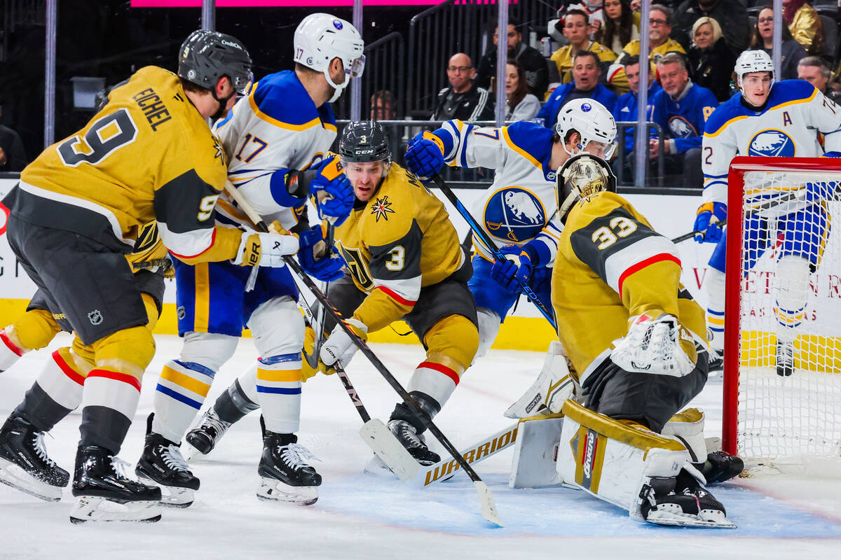 Golden Knights defenseman Brayden McNabb (3) tries to fish the puck out from a Buffalo Sabres a ...