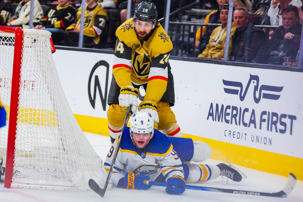 Golden Knights defenseman Nicolas Hague (14) tries to reach for the puck over Buffalo Sabres le ...