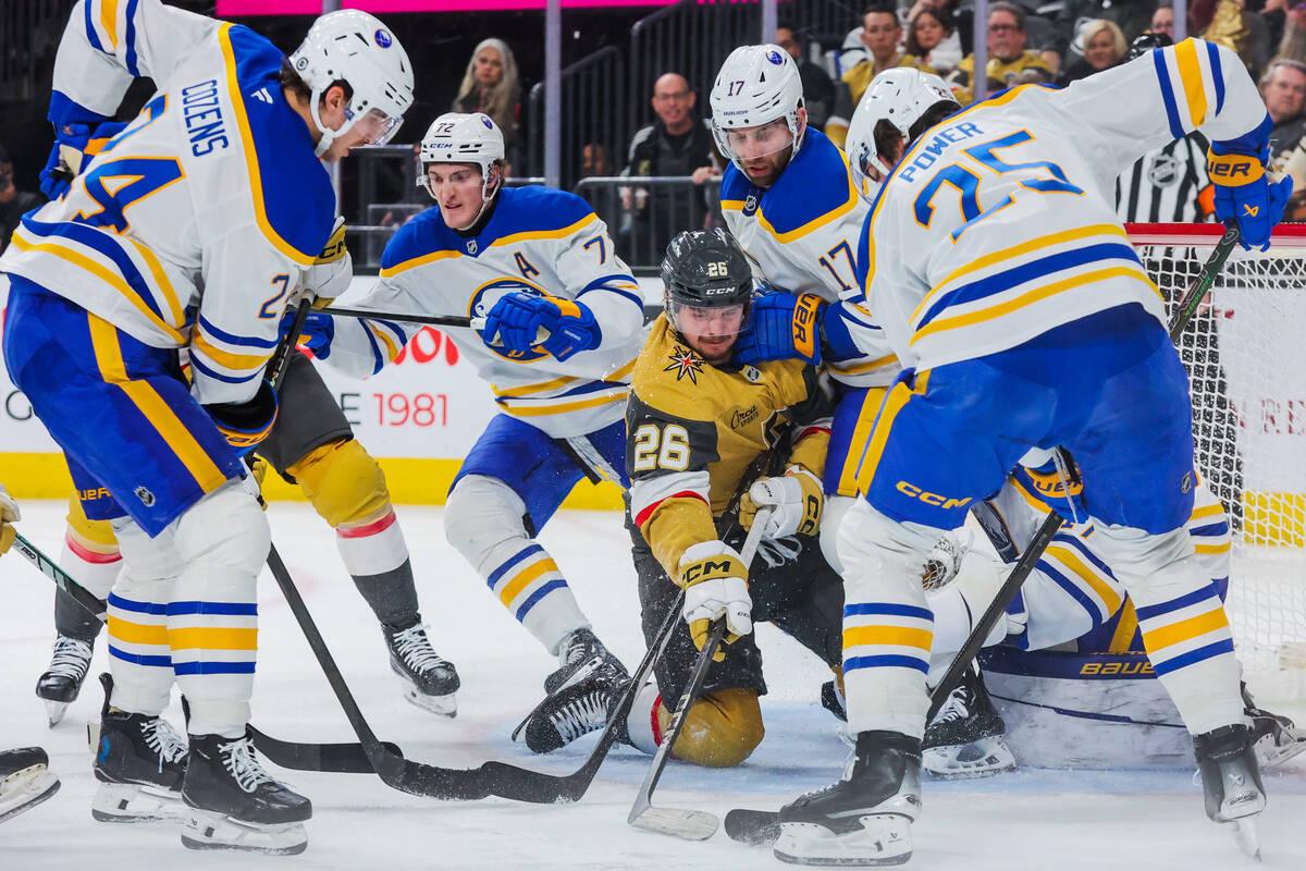 Golden Knights right wing Alexander Holtz (26) fishes the puck out to attempt a goal during an ...