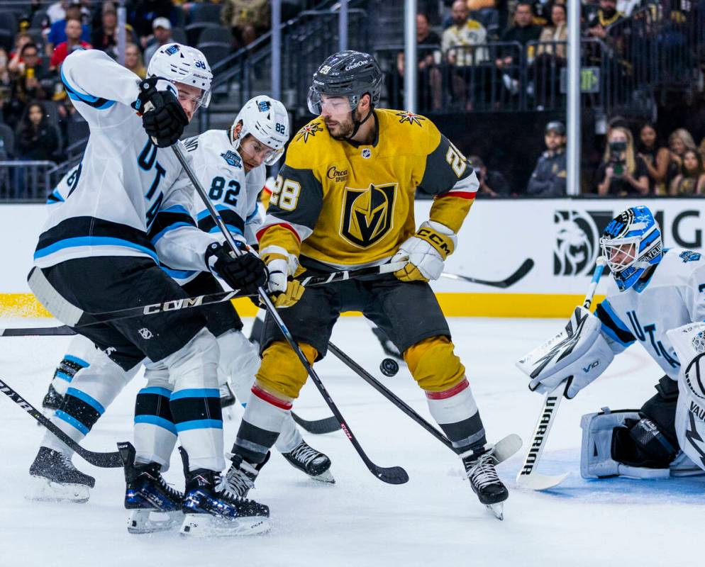 Golden Knights center Tanner Laczynski (28) fights for the puck with Utah Hockey Club forward K ...