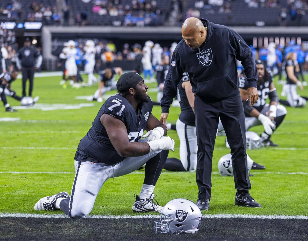 Raiders head coach Antonio Pierce chats with Raiders offensive tackle DJ Glaze (71) during warm ...