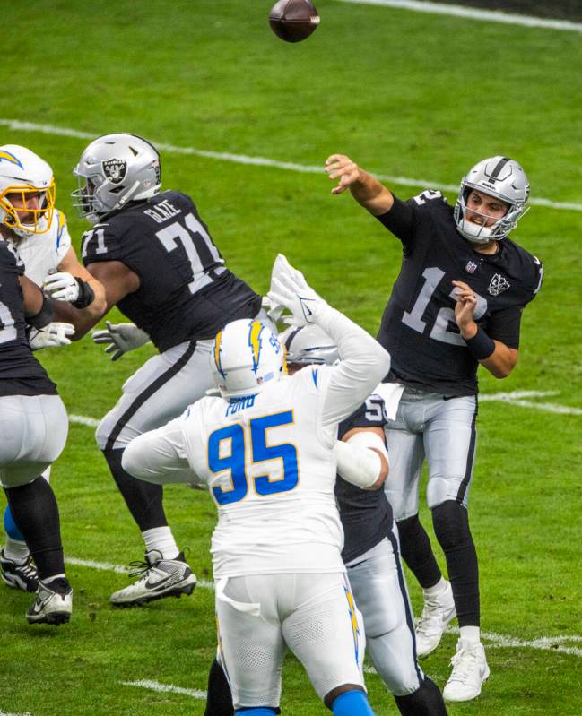 Raiders quarterback Aidan O'Connell (12) gets off a pass against the Los Angeles Chargers durin ...