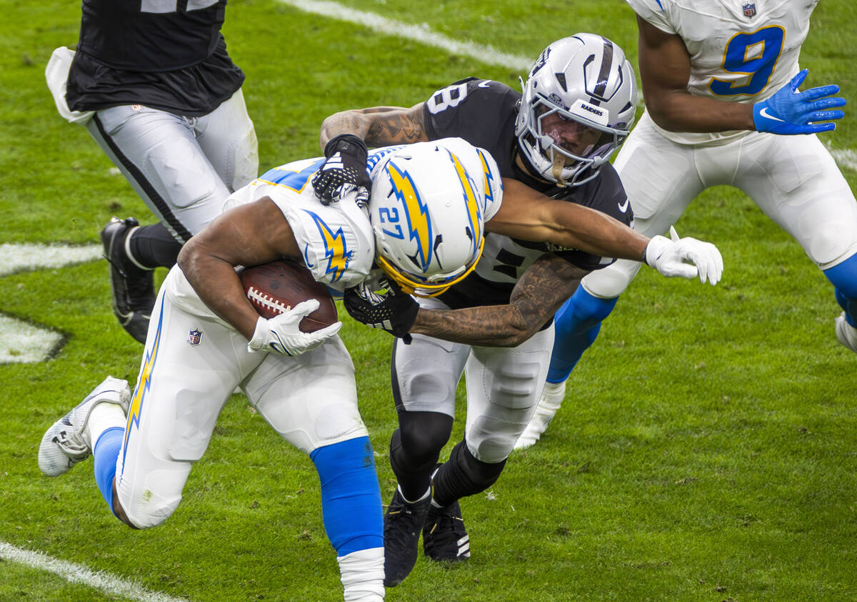 Los Angeles Chargers running back J.K. Dobbins (27) is tackled by Raiders cornerback Jack Jones ...