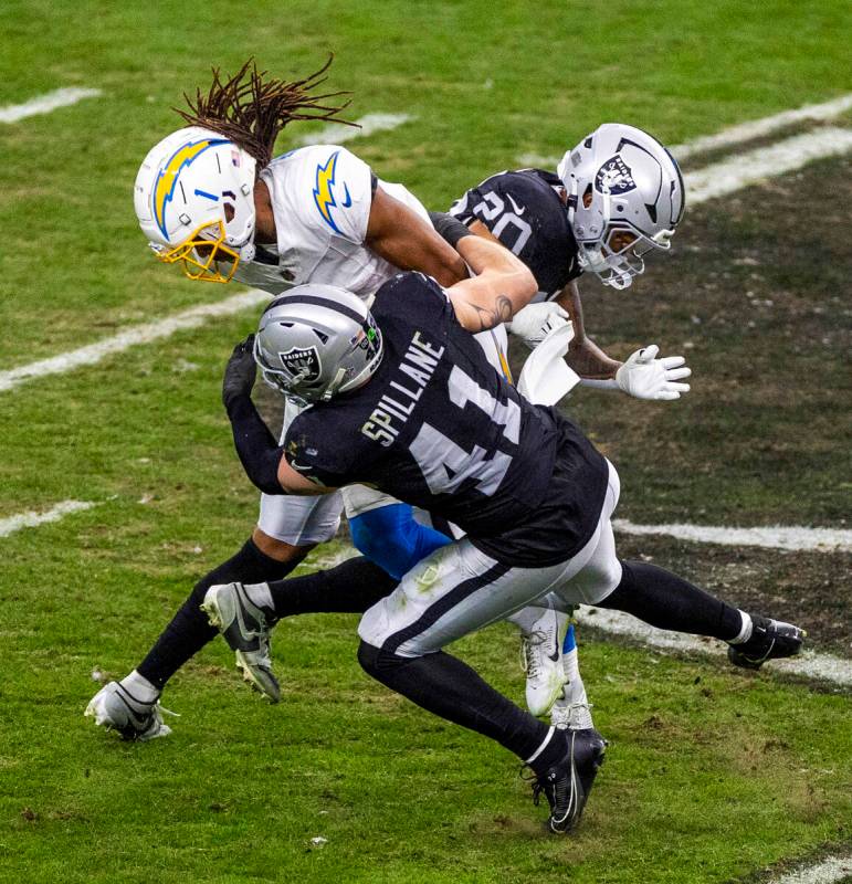 Raiders linebacker Robert Spillane (41) tackles Los Angeles Chargers wide receiver Quentin John ...