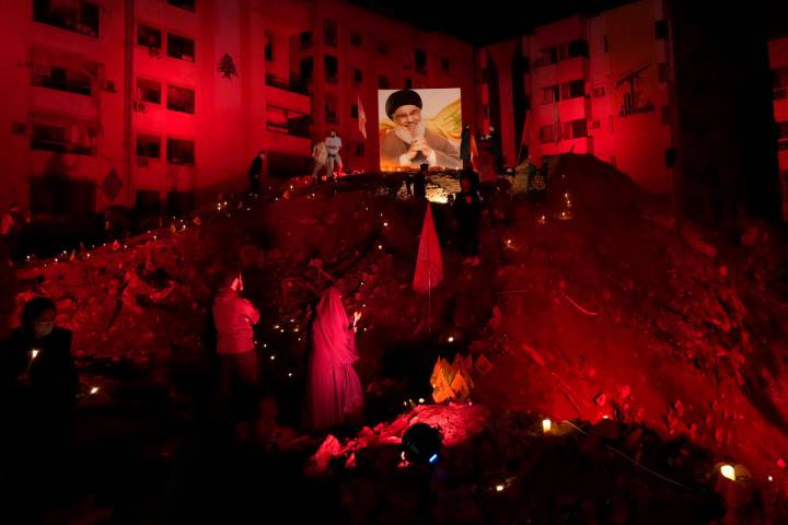 FILE - A woman lights candles at the site where former Hezbollah leader Hassan Nasrallah was ki ...