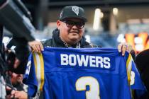 A Raiders fan holds up Raiders tight end Brock Bowers’ high school jersey during an NFL ...