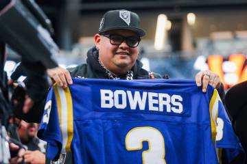 A Raiders fan holds up Raiders tight end Brock Bowers’ high school jersey during an NFL ...