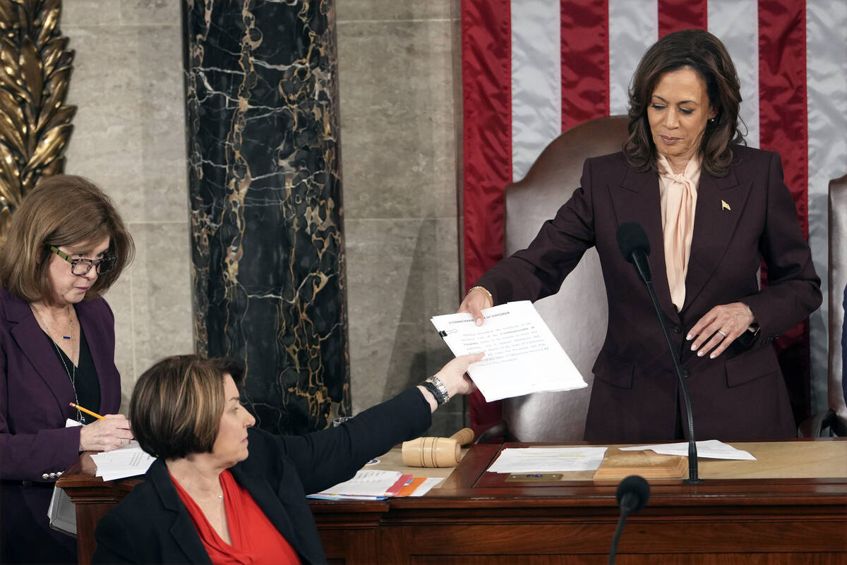 Vice President Kamala Harris hands the certification for Virginia to teller Sen. Amy Klobuchar, ...