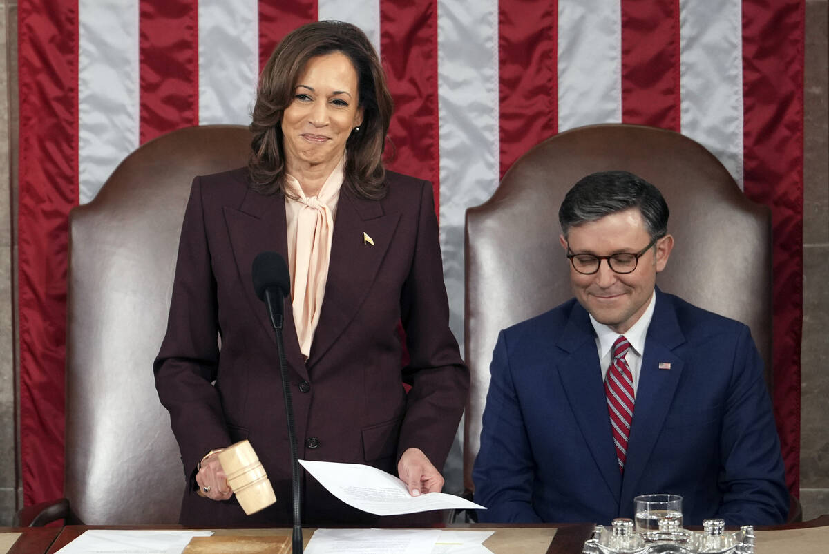 Vice President Kamala Harris reads the results as House Speaker Mike Johnson, R-La., listens du ...