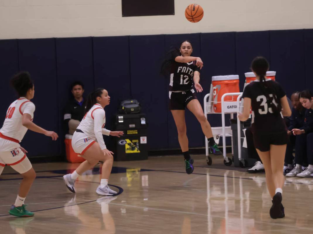 Faith Lutheran's Aliyah Maese (12) throws a pass to Emma Herpin (33) during a high school baske ...