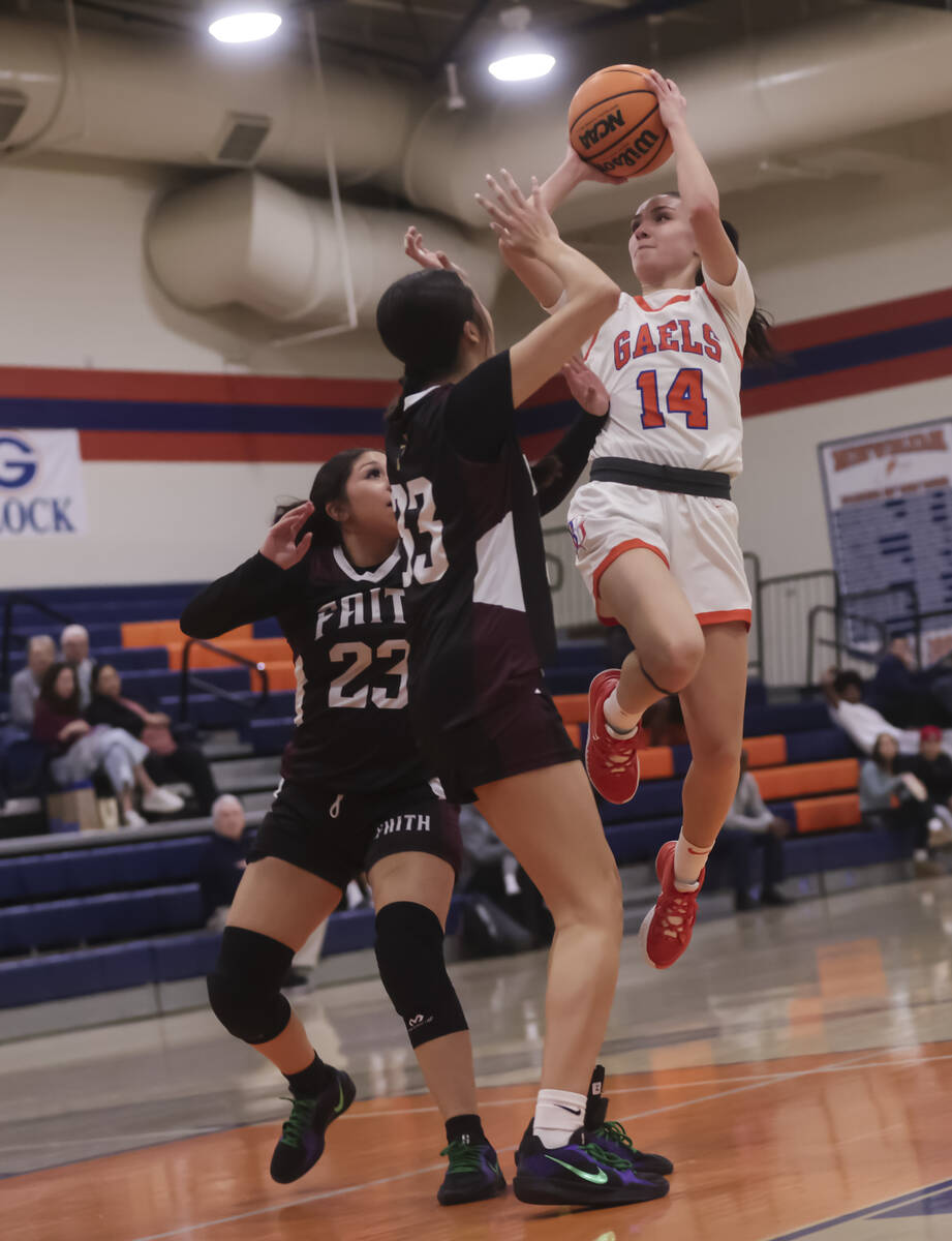 Bishop Gorman's Kenzee Holton (14) shoots over Faith Lutheran's Emma Herpin (33) during a high ...