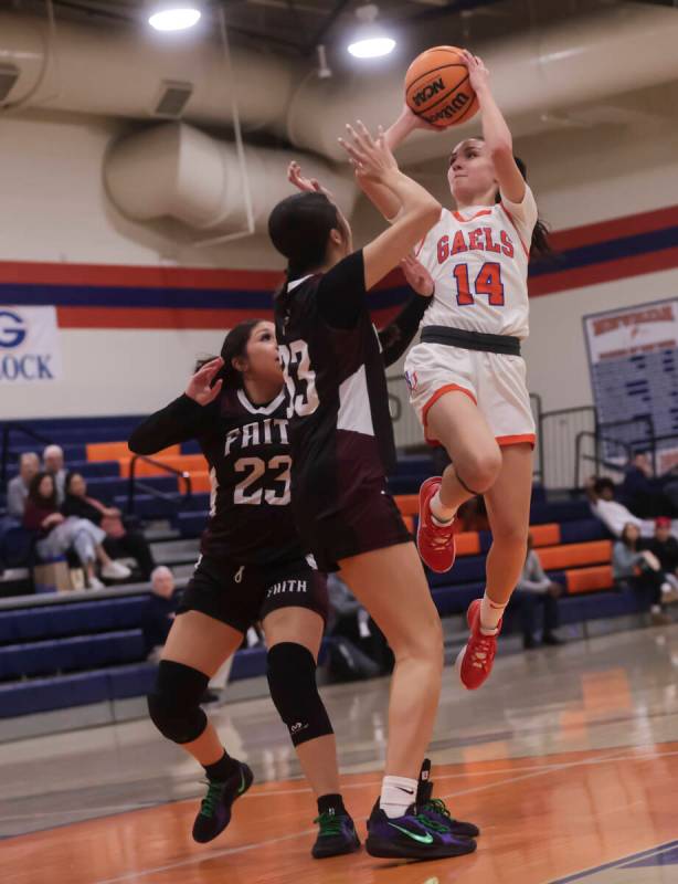 Bishop Gorman's Kenzee Holton (14) shoots over Faith Lutheran's Emma Herpin (33) during a high ...