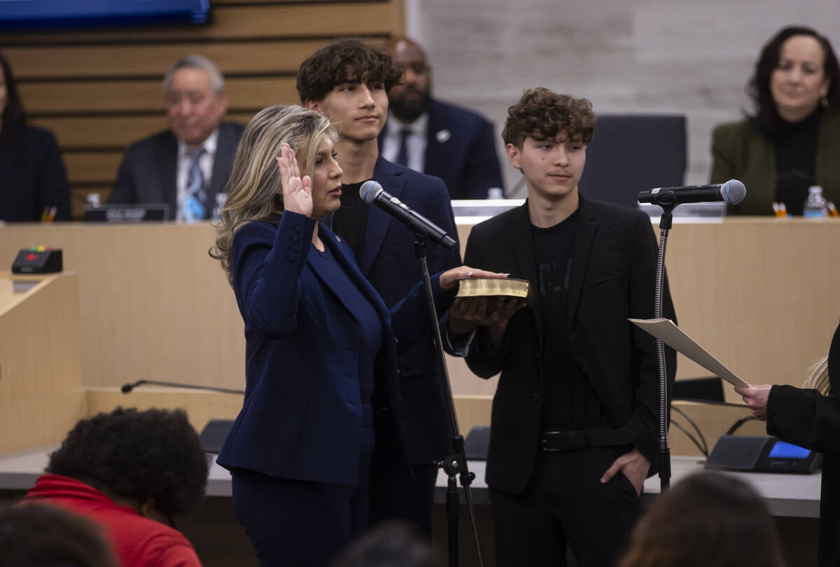 New Clark County School Board trustee Lydia Dominguez is sworn while standing next to her two s ...