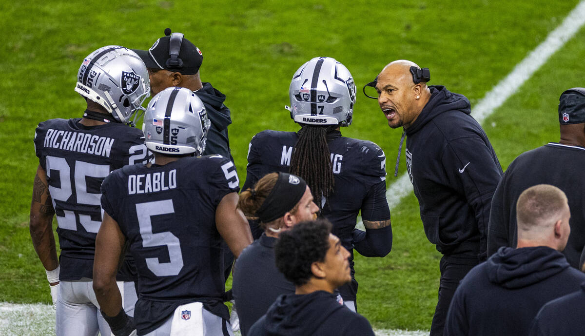 Raiders head coach Antonio Pierce has a serious conversation with safety Tre'von Moehrig (7) on ...