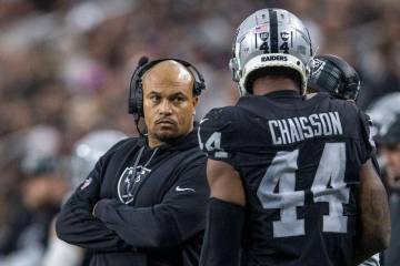 Raiders head coach Antonio Pierce looks on as Raiders defensive end K'Lavon Chaisson (44) retur ...