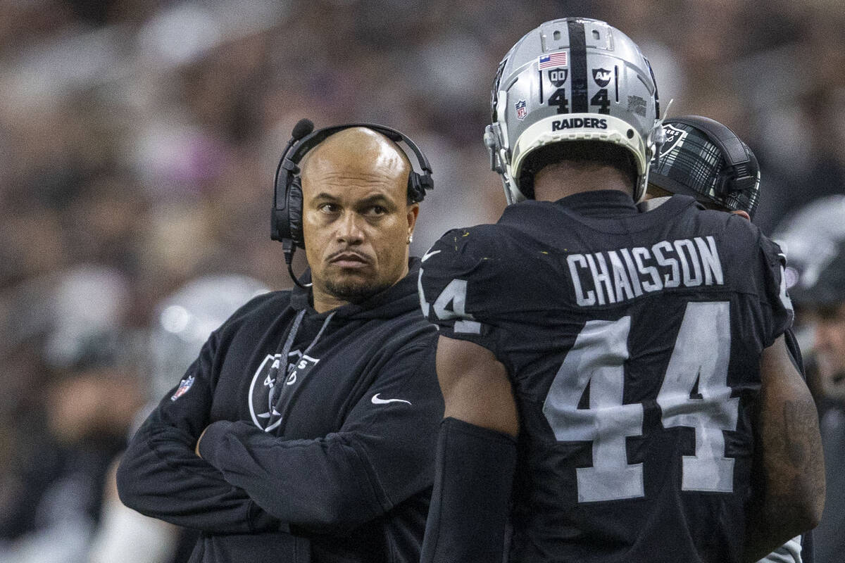 Raiders head coach Antonio Pierce looks on as Raiders defensive end K'Lavon Chaisson (44) retur ...