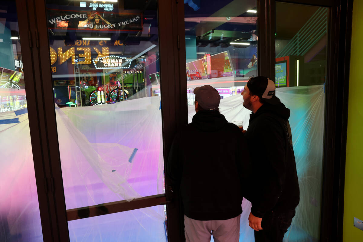 Passers by check out the opening-soon In The Game arcade business at the Fremont Street Experie ...