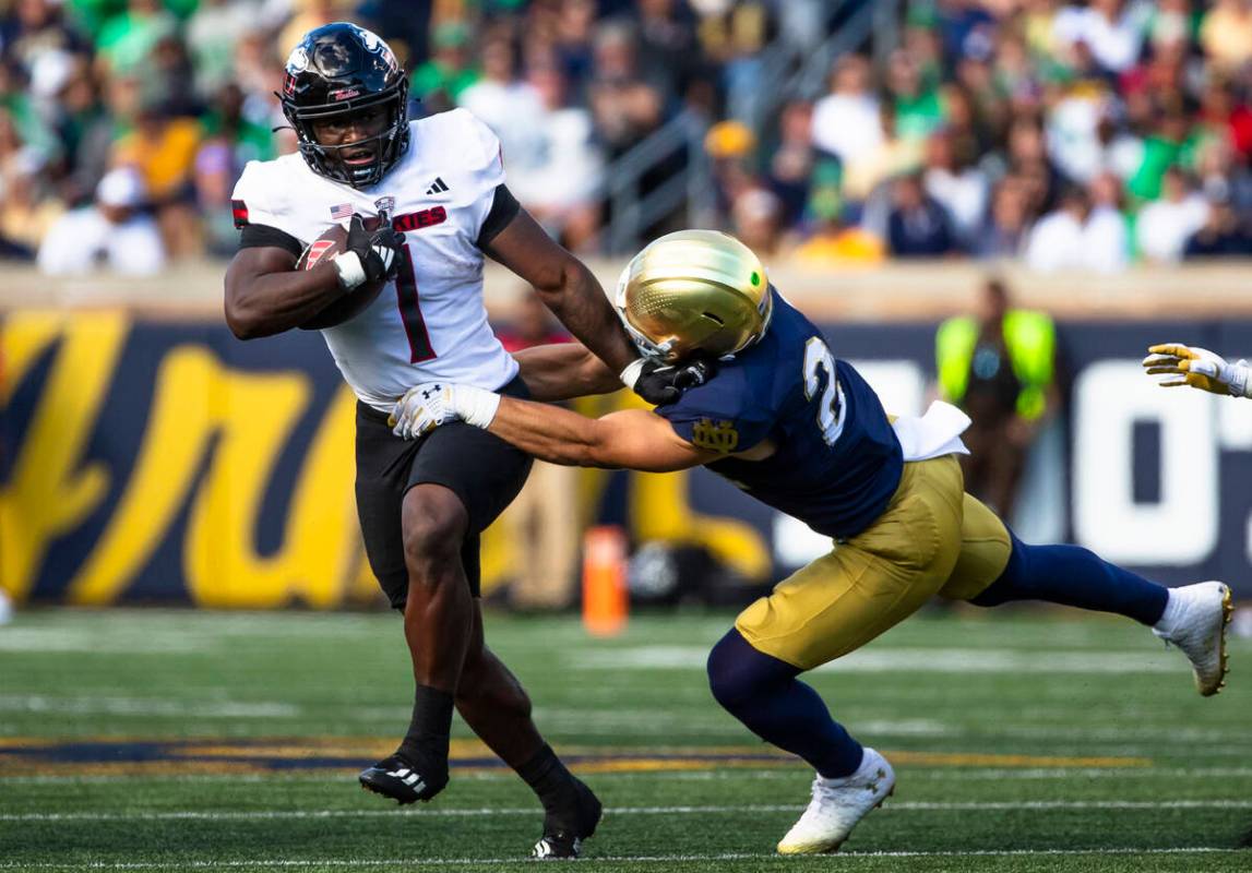 Northern Illinois running back Antario Brown (1) tries to get past Notre Dame running back Jada ...