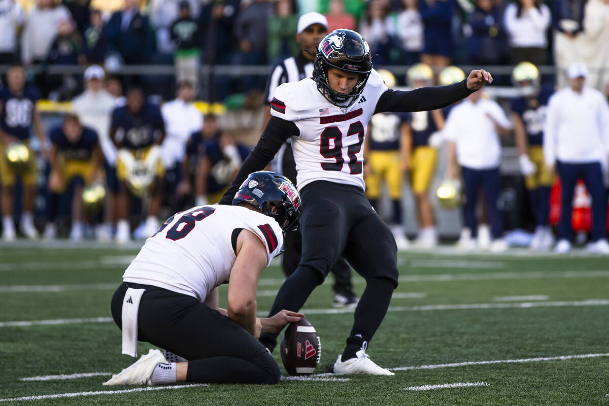 Northern Illinois kicker Kanon Woodill (92) makes a go-ahead field goal as punter Tom Foley, le ...