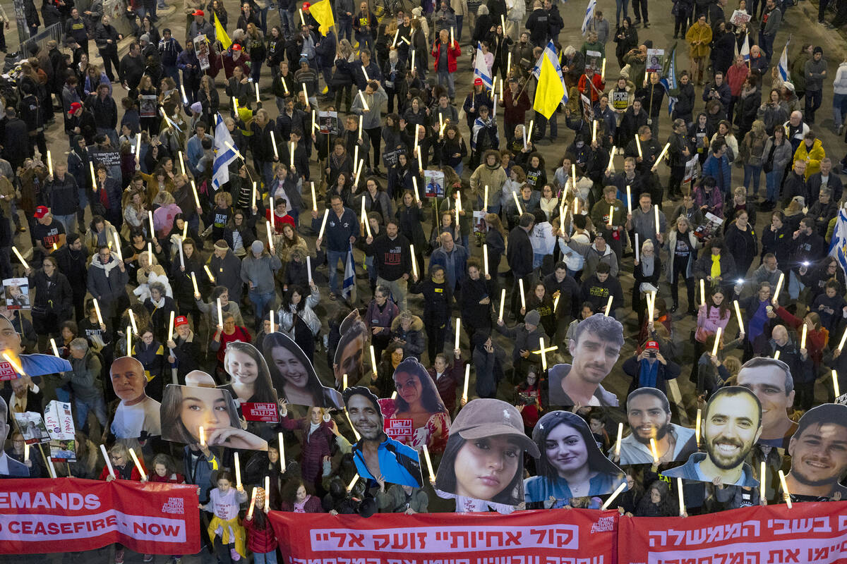 Protesters hold photos of hostages held in the Gaza Strip and 100 light sticks to symbolize 100 ...