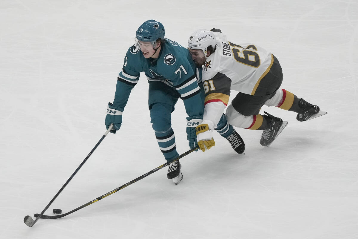 Vegas Golden Knights right wing Mark Stone (61) reaches for the puck from behind San Jose Shark ...