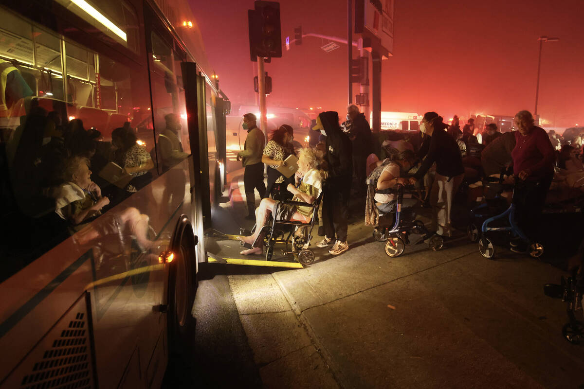 Residents of a senior center are evacuated and loaded into a bus as the Eaton Fire approaches T ...