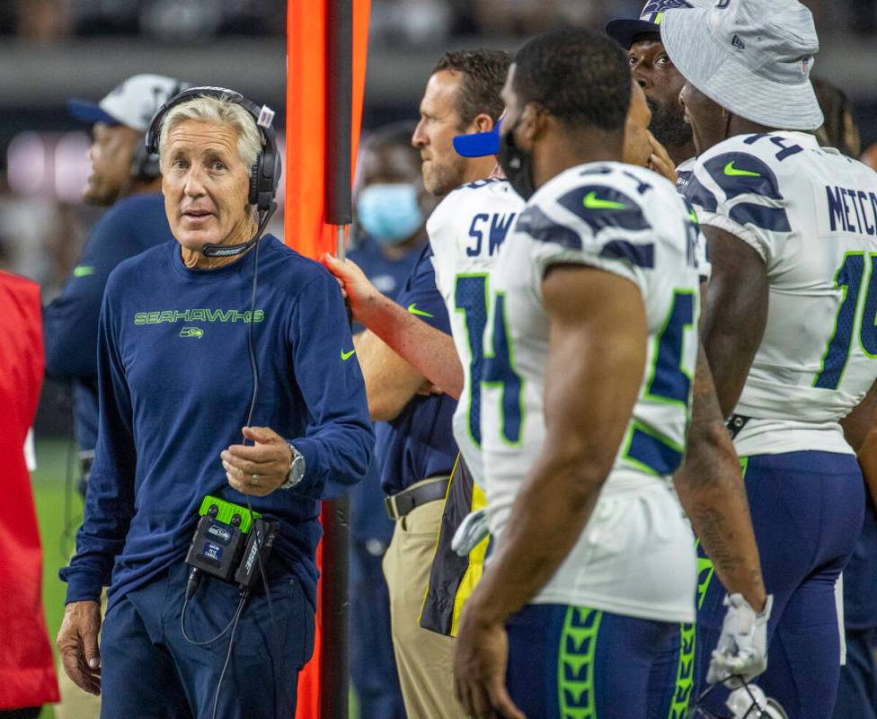 Seattle Seahawks head coach Pete Carroll tosses a piece of gum to a player on the sidelines dur ...