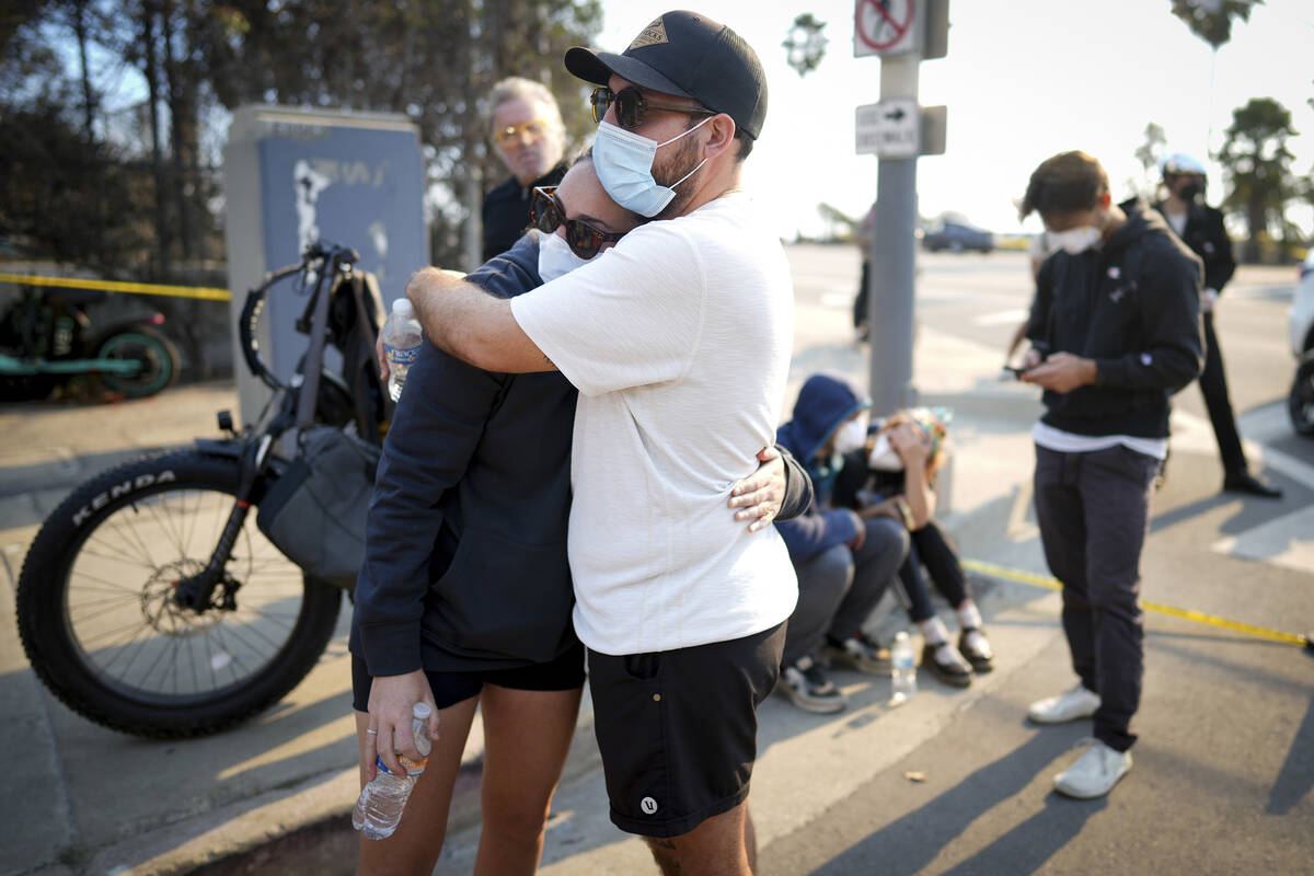 Ethan Sarani, and his fiancée Hannah Simon hug as they wait for access to their community ...