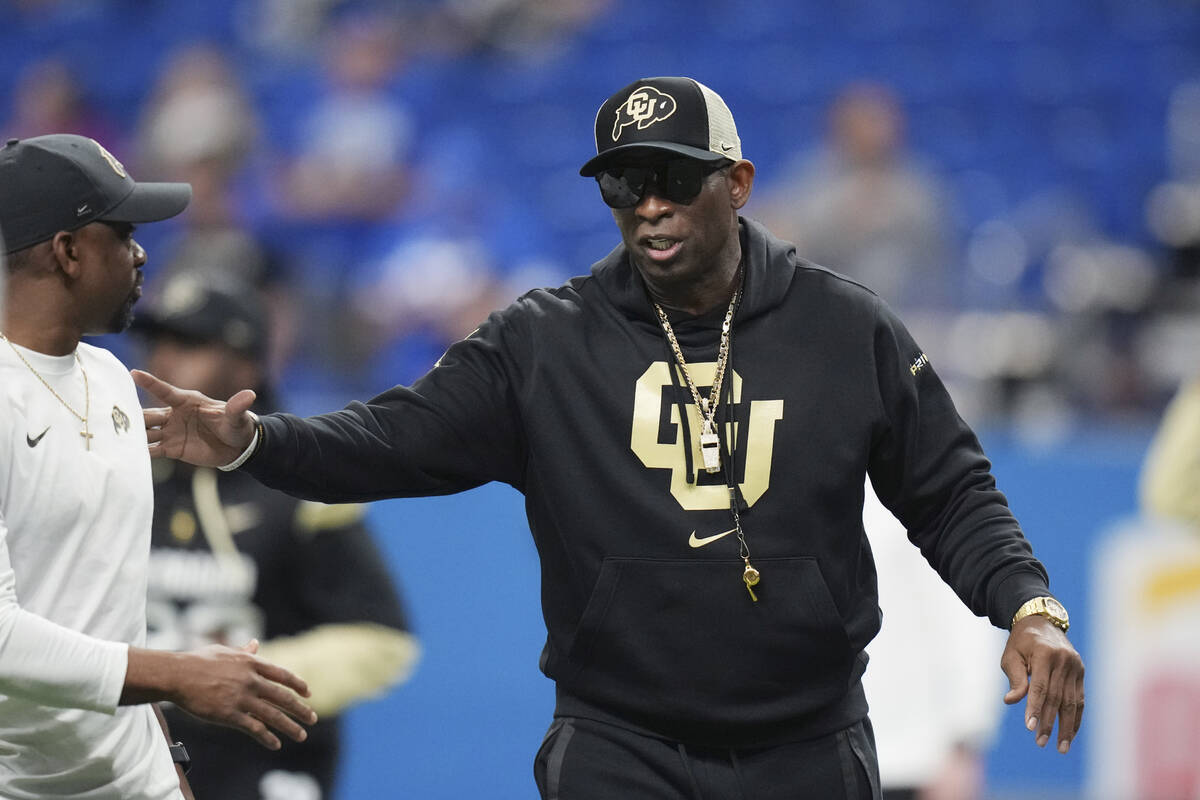 Colorado head coach Deion Sanders watches his players warm up for the Alamo Bowl NCAA college f ...