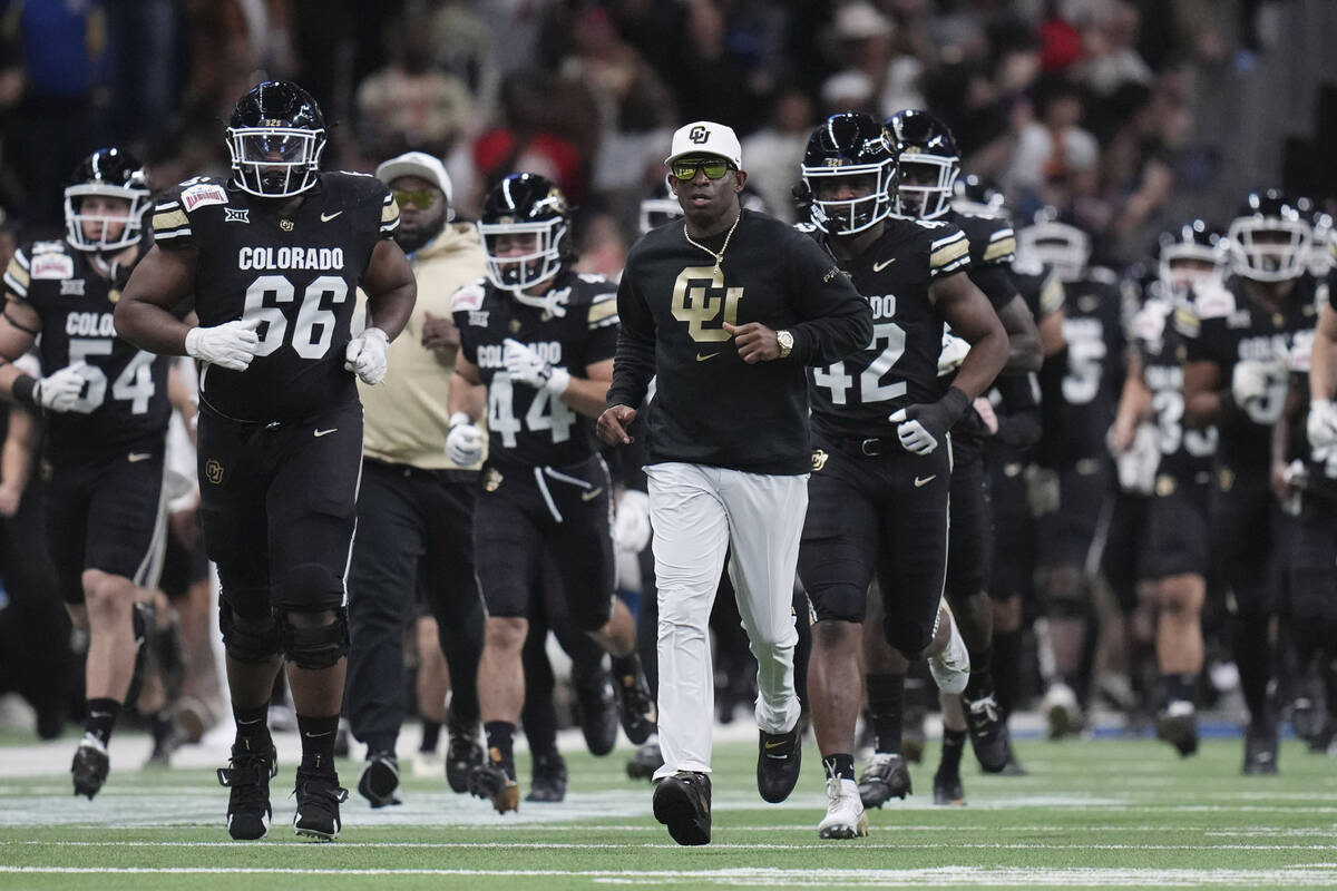 Colorado head coach Deion Sanders, center, takes the field with his team before the Alamo Bowl ...