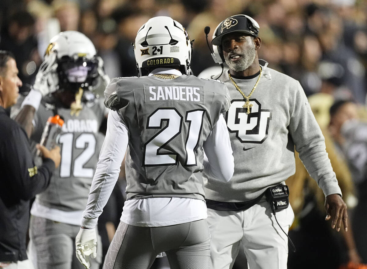 Colorado head coach Deion Sanders, right, confers with his son, safety Shilo Sanders (21), in t ...