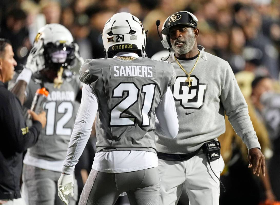 Colorado head coach Deion Sanders, right, confers with his son, safety Shilo Sanders (21), in t ...