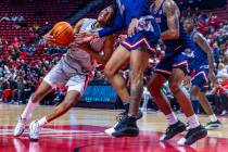 UNLV guard Jaden Henley (10) its founder by Fresno State Bulldogs forward Mykell Robinson (11) ...