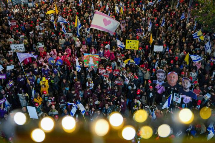 Demonstrators wave Israeli flags and signs during a protest calling for the immediate release o ...