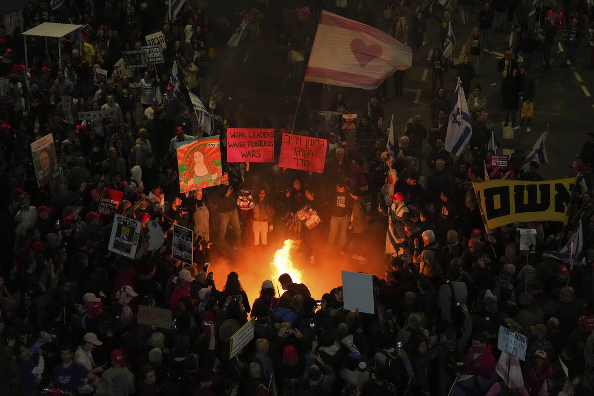 Demonstrators light a bonfire during a protest demanding a cease-fire deal and the immediate re ...