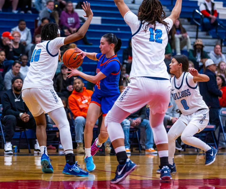 Bishop Gorman guard Kenzee Holton (14) passes while covered all around by Centennial guard Sana ...