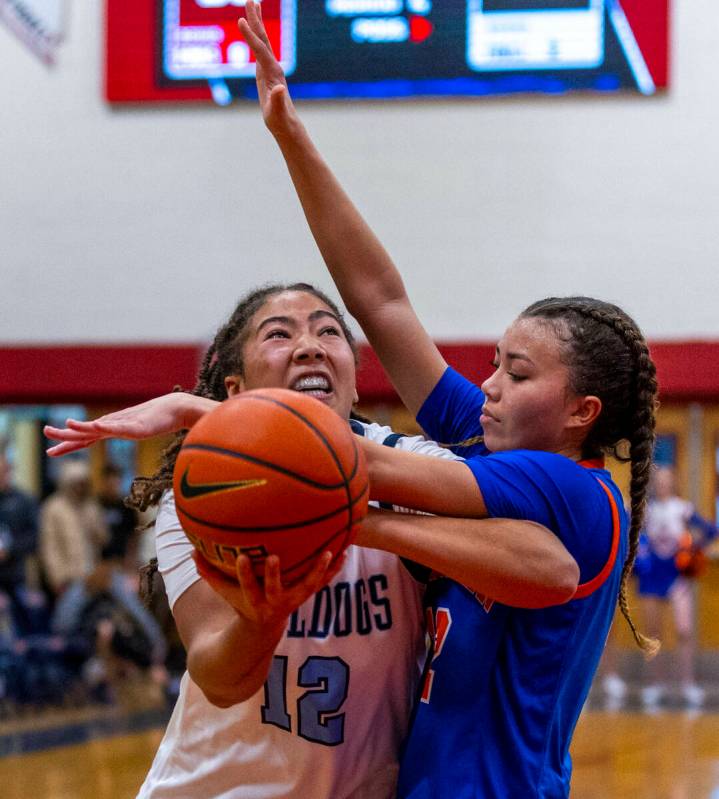 Centennial's forward Ayla Williams (12) is fouled but still shoots under Bishop Gorman's guard ...