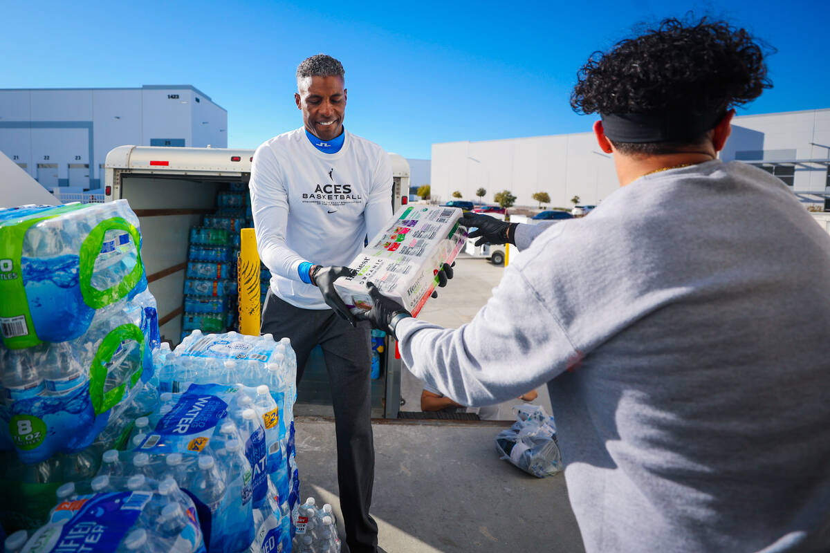 Larry Lewis, Aces assistant coach, helps sort donations with Aces staff to send to victims of t ...