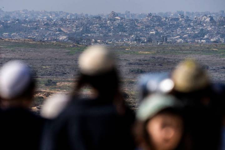 People watch the Gaza Strip from an observation point in Sderot, southern Israel, Monday, Jan. ...