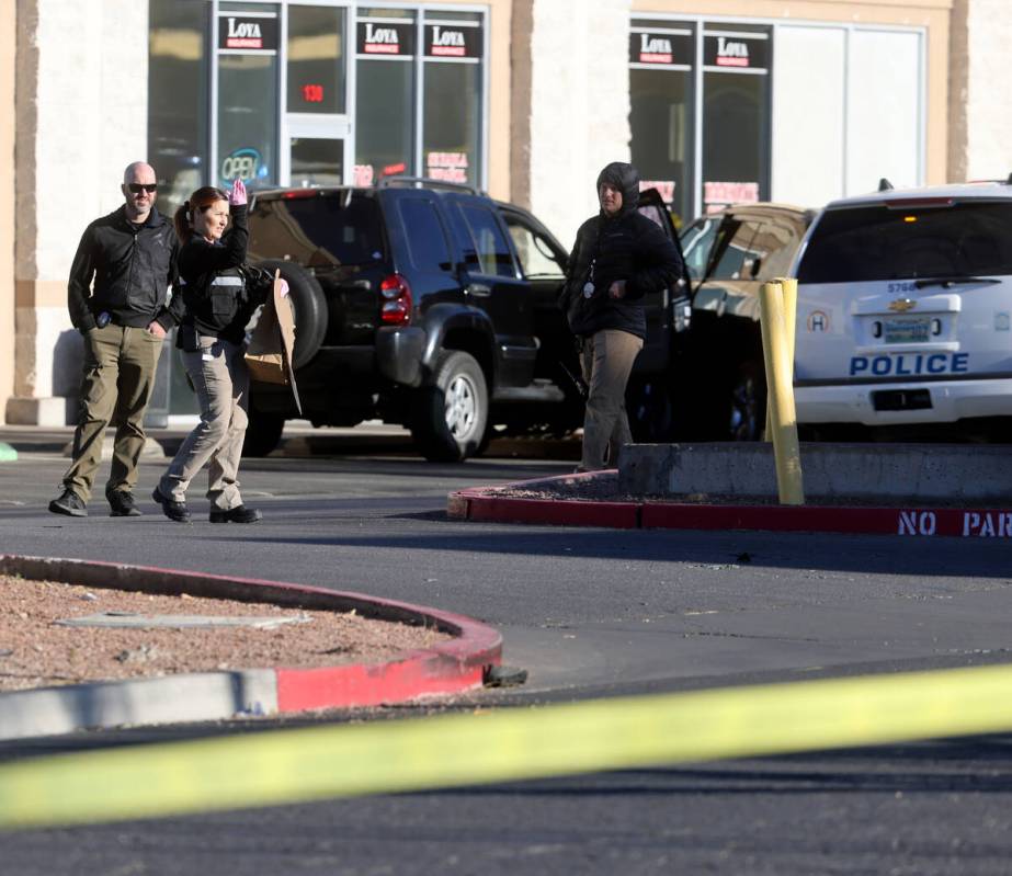 Henderson Police investigate the scene of an officer involved shooting that injured an officer ...